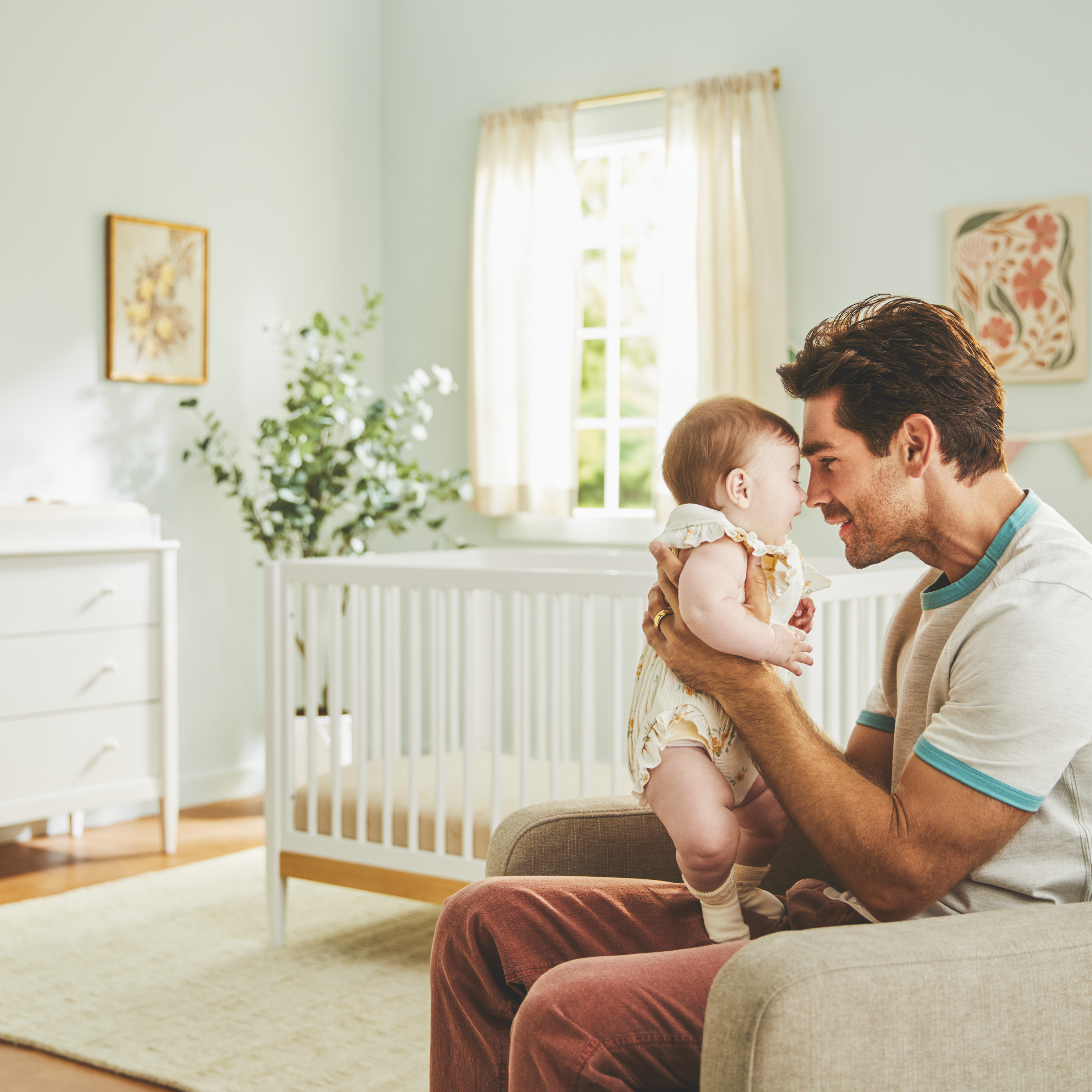 Clover 4-in-1 Convertible Crib - father holding baby in foreground with crib in background